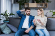 © Liubomir - Sad man and woman sitting on the couch, disappointed with a negative pregnancy test