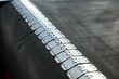 © Пётр Гребенев - Close-up of a rubber conveyor belt connected by a flexible metal joint.Selective focus.