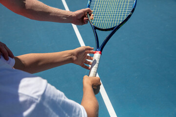 Instructor teaches proper grip on tennis racquet