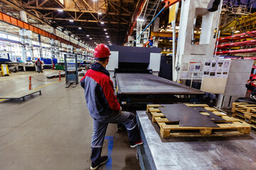 Wall Mural - Worker works with metal sheet forming machine at the metalwork factory