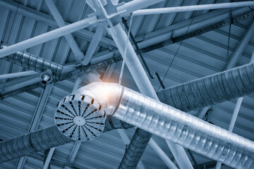 Poster - Ventilation pipes in silver insulation material hanging from the ceiling inside new building.