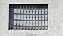 Window With Grille And Shutter On White Rustic Facade