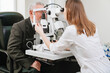 © andrey - ophthalmologist examination of elderly man with slit lamp. medical equipment