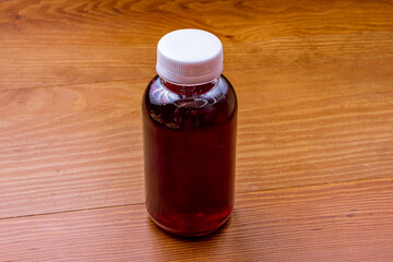 Wall Mural - a bottle of red compote on wooden table side view
