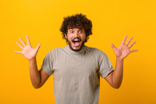 Incredible Promotion. Amazed Indian Man In Casual T-shirt Looks At The Camera With Mouth Open Isolated On Yellow, Close-up Portrait Of Surprised Multiracial Guy