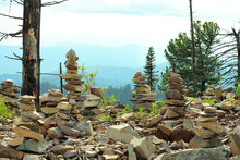 Sacred Stone Pyramids, Young Pine Trees And Dry Tree Trunks On A Hilltop Overlooking The Mountain Ranges.