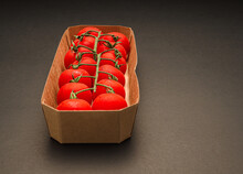 A Box With Red Ripe Fresh Cherry Tomatoes With Green Stems On The Branch Over The Vintage Background