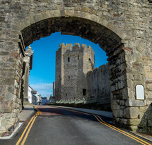 Caernarfon Castle,through The Archway Of The Ancient Town Walls,leading Past Imposing Towers,North Wales,United Kingdom.