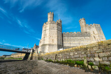 Caernarfon Castle,low Angle View Of Sea Walls,from Banks Of The River Seiont At Low Tide,Wales,United Kingdom.