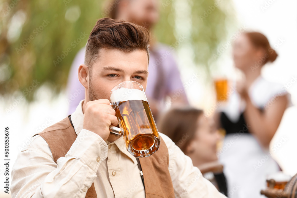 Man with beer celebrating Octoberfest outdoors