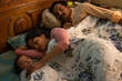 © IndiaPix - Portrait of little baby sleeping with parent on bed