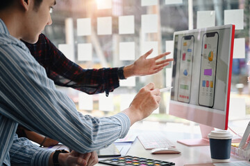 Wall Mural - two professionals web developers working together for mobile application software design project.