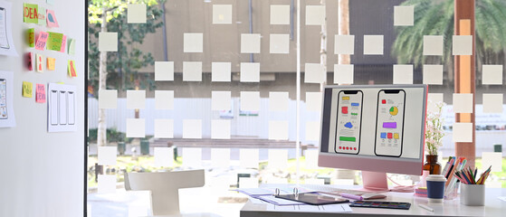 Wall Mural - computer with wireframe, sketches of mobile application on screen, document and office supplies on w