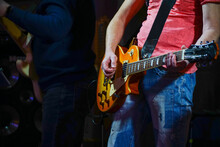 A Guitarist In Jeans Plays The Guitar. Hands Of A Guitar Player Playing The Guitar. Selective Focus. Soft Focus