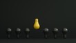Yellow bulb inverted and higher among black bulbs on dark background. Leadership, authority, great idea concepts. 