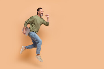 Sticker - Full body photo of excited sporty man look empty space hurry rush isolated on beige color background