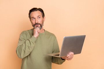 Sticker - Portrait of attractive minded skilled man using laptop deciding copy space isolated over beige pastel color background