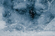 Leinwandbild Motiv Ice texture background. Textured, dark blue-toned, the cold, cracked, frosty surface of an ice block.
