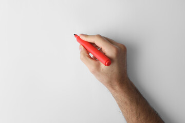 Wall Mural - Man holding red marker on white background, top view