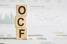 Concept Word OCF On Wooden Cubes On A Chrt Background. Inscription On A Financial, Business Or Economic Theme. OCF - Short For Operating Cash Flow