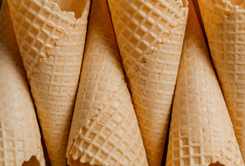 Close-up of waffle cones. Top view of the sugary texture of waffle cones. Blanks for dessert and ice cream. Creative macro concept of sweets and food