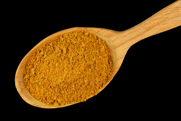 Sticker - Curry powder seasoning in a wooden spoon black background