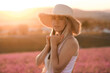 © morrowlight - Beautiful smiling woman wear straw hat and dress standing in purple lavender flower field outdoor over nature background. Summer season. Springtime.