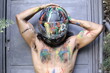 Muscular unrecognizable motorcycle rider with artsy body paint