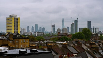 Sticker - London, UK. Aerial view of a residential district with modern skyscrapers in the background in London, UK. Heavy clouds over the city. Time-lapse at day