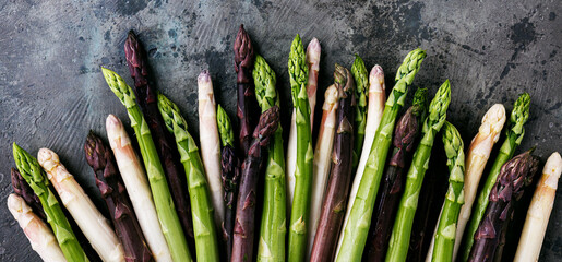 Green, white and purple asparagus on a kitchen background