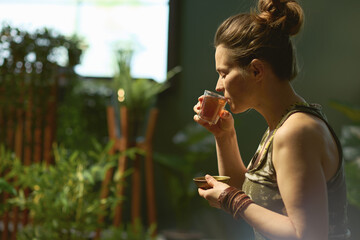 modern female with tea in modern green living room