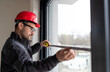 © Budimir Jevtic - Male worker measuring window with measuring tape.