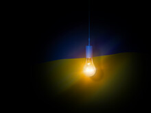 Electric Light Bulb On A Dark Background Illuminates The Flag Of Ukraine. 3d Illustration