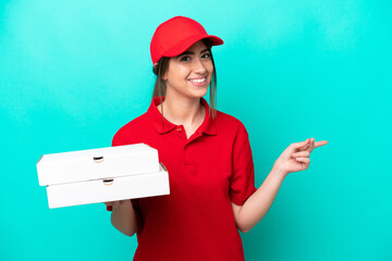 Wall Mural - Pizza delivery woman with work uniform picking up pizza boxes isolated on blue background pointing back