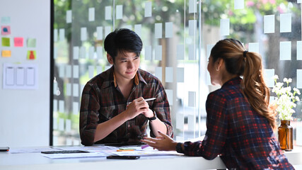 Wall Mural - two professionals web developers brainstorming and working together for mobile application software 