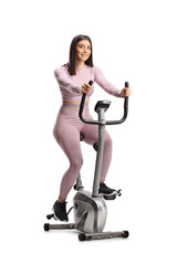 Wall Mural - Young fit woman in sportswear riding a stationary bike