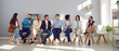 Narrow wide shot of diverse employees sit on chairs in row brainstorm or discuss ideas. Banner of smiling multiethnic candidate in line before office meeting or interview. Employment concept.