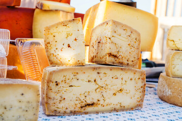 Production and sale of farm cheese. Dairy products on the counter in the market. Close-up