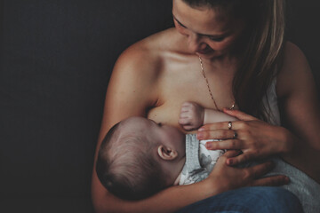 Wall Mural - Mom breastfeeding newborn baby at home