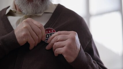 Wall Mural - Senior man wearing vote badge on election day, citizen showing civil position