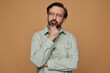 © timtimphoto - studio portrait of bearded man posing over beige background looking aside with serious facial expression