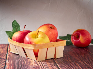 Wall Mural - Bright apples in a basket on a light background