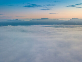  The rays of dawn over the fog in the Ukrainian Carpathians. Aerial drone view.