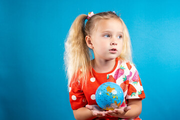 The girl is holding a globe in her hands. The concept of children's dream, the future of the younger generation, children's education, world peace, globalization, ecology and global warming