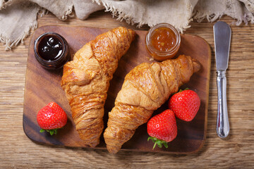 Wall Mural - fresh croissants and strawberry on wooden board