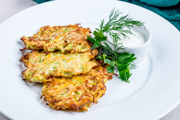 Wall Mural - Fried potato pancakes with sour cream on white plate