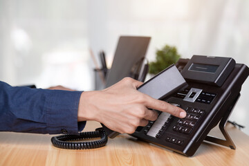 Call center staff man hand point to press the button number on the phone office desk , Communication support, call center and customer service help desk. for (call center) concept