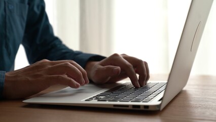Wall Mural - businessman hand work on capable laptop computer at office table close up shot and selective focus a