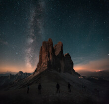 Boy, Man Is Standing In Front Of Moutains Tre Cime Di Lavaredo In Dolomites, Italy During Night With Full Of Stars And Milky Way. Amazing Landscape Night Photo With Atmosphere. 