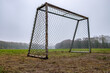 Desolation. An old practice soccer goal on a bad fall day. Fog. No people.